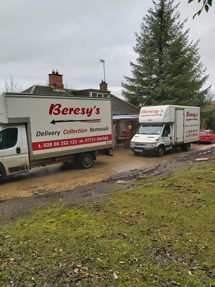 Two Beresy's House Removals vans parked near a field