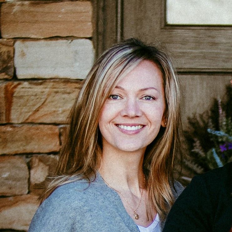 Elena Kissina in front of brick wall and black door.