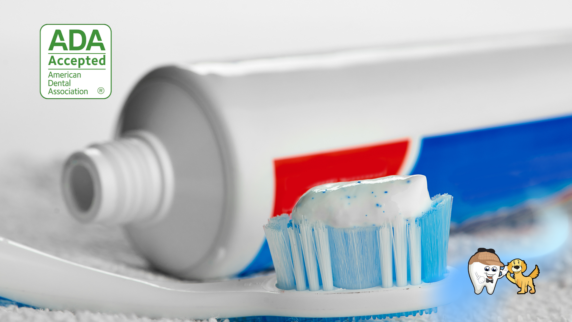 A tube of toothpaste is next to a toothbrush with toothpaste on it.