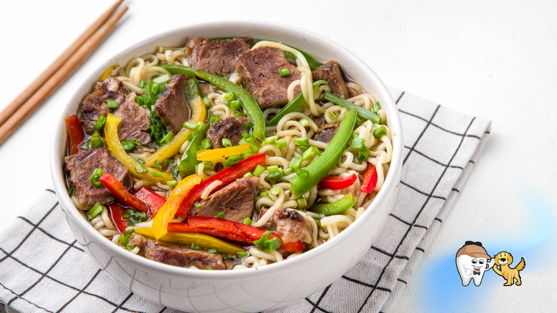 Bowl of ramen with beef, peppers, and scallions. Chopsticks rest beside.