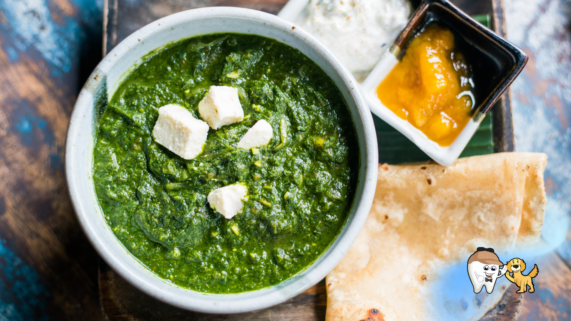 Palak paneer in bowl with roti, chutney, and yogurt on a platter.