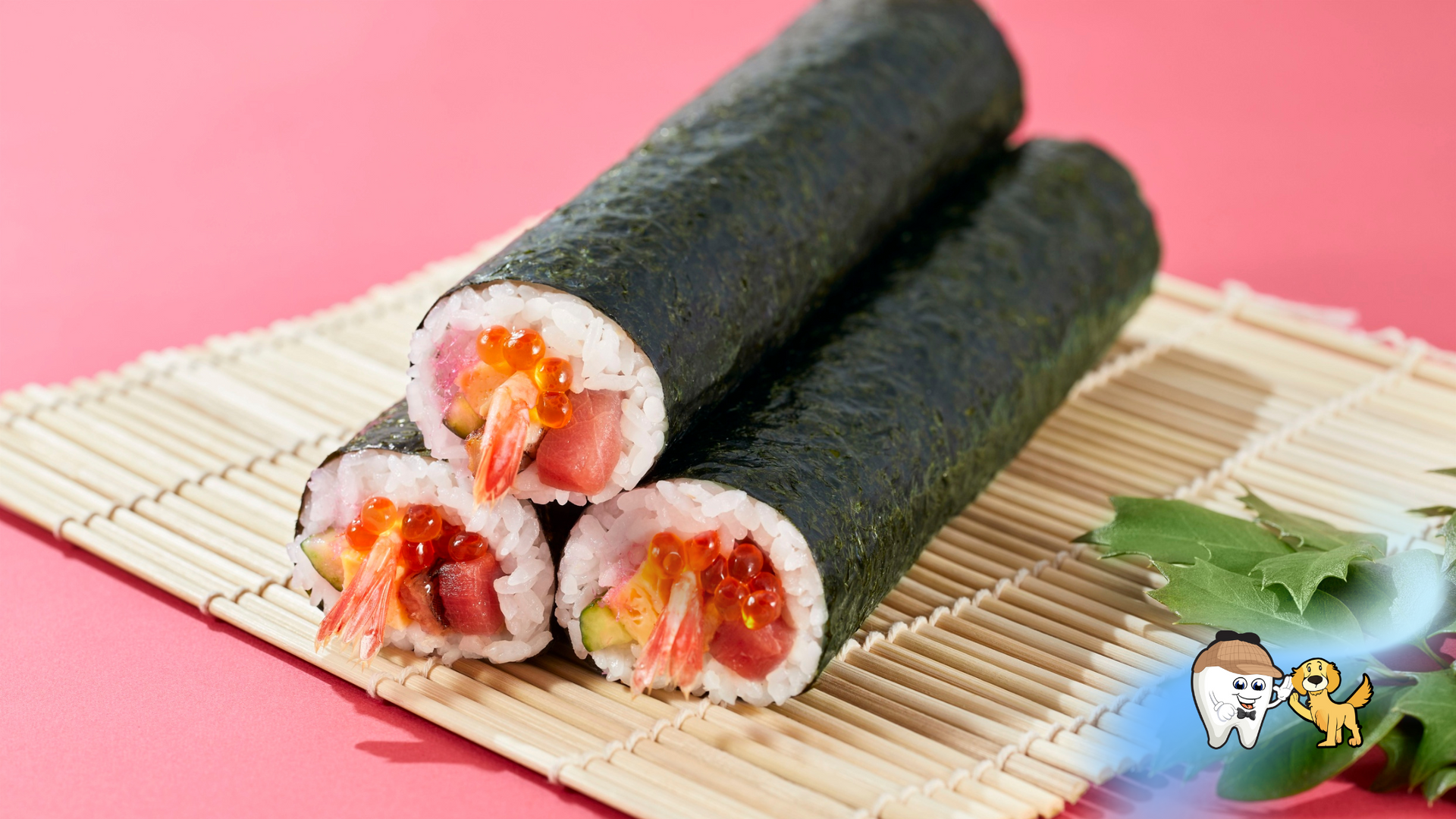 Sushi rolls on a bamboo mat, cut open to reveal fillings of seafood and roe. Pink background.