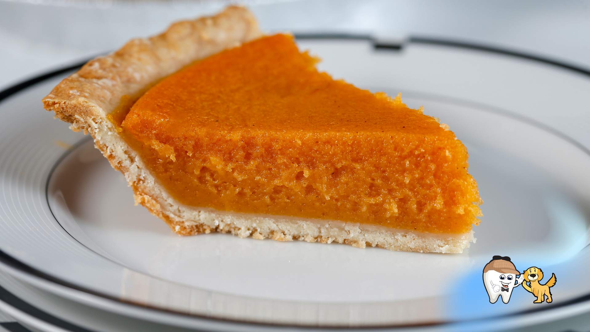 Slice of sweet potato pie on a white plate with black trim; orange filling, golden crust.
