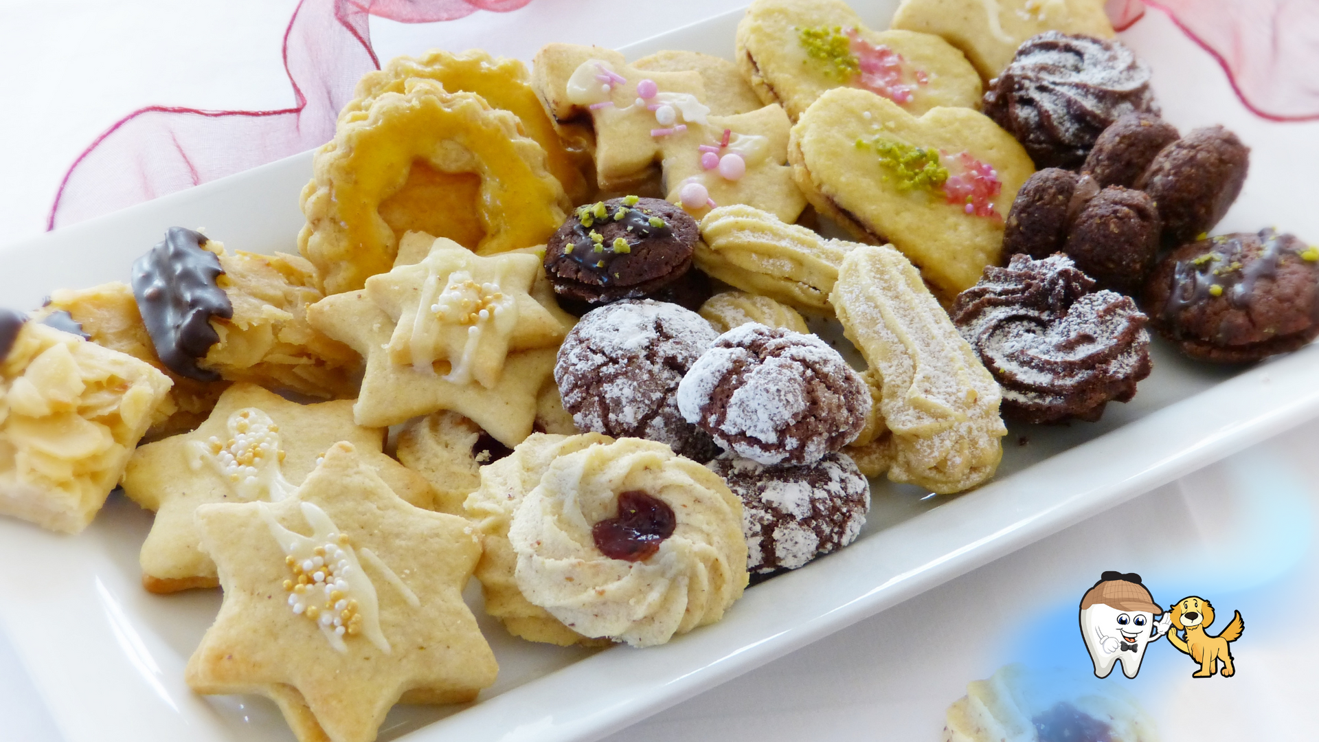 Assorted cookies on a white platter, including stars, hearts, and chocolate, with some dusted in powdered sugar.