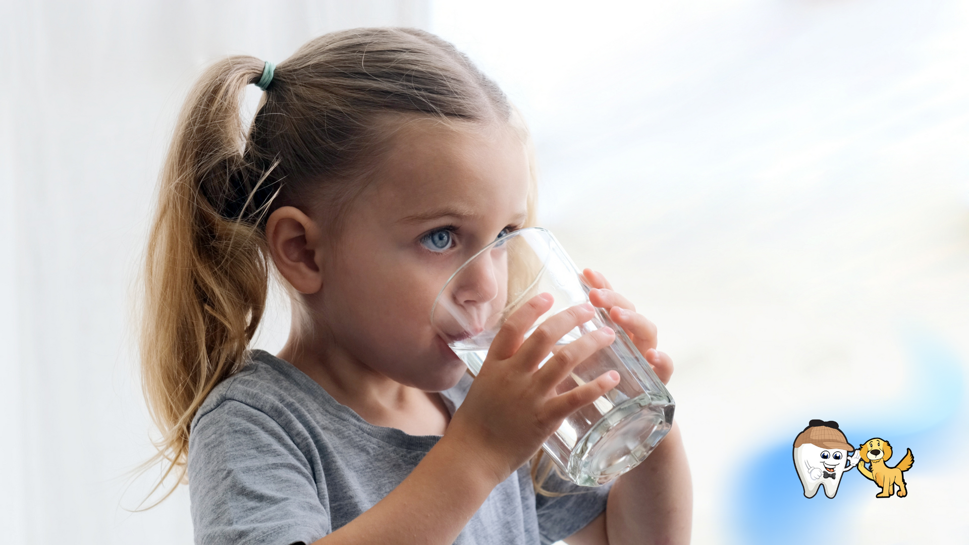 Girl drinking water from a glass, ponytail, gray shirt, light background.