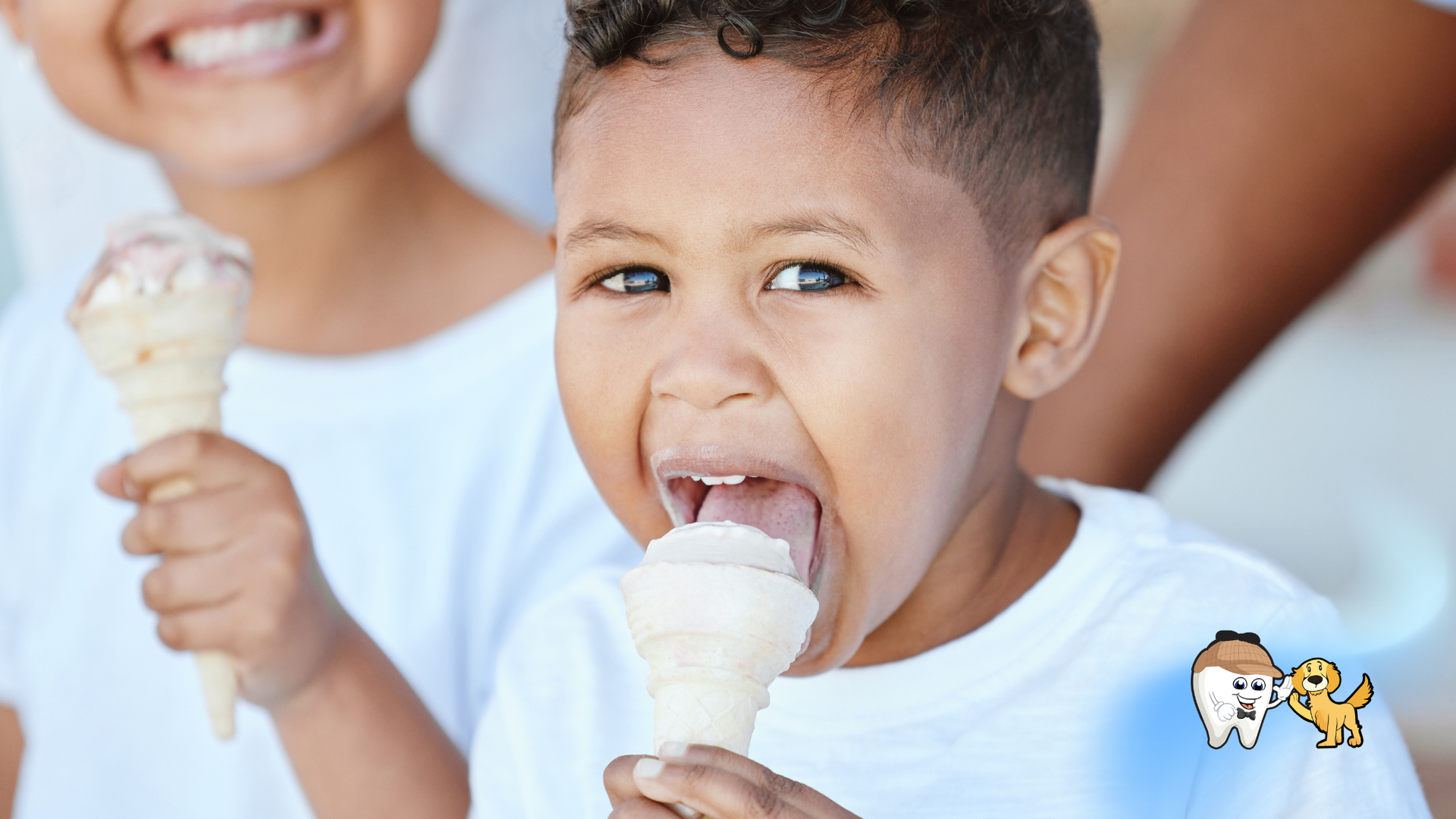 Two children eating ice cream cones, one with mouth open, smiling.