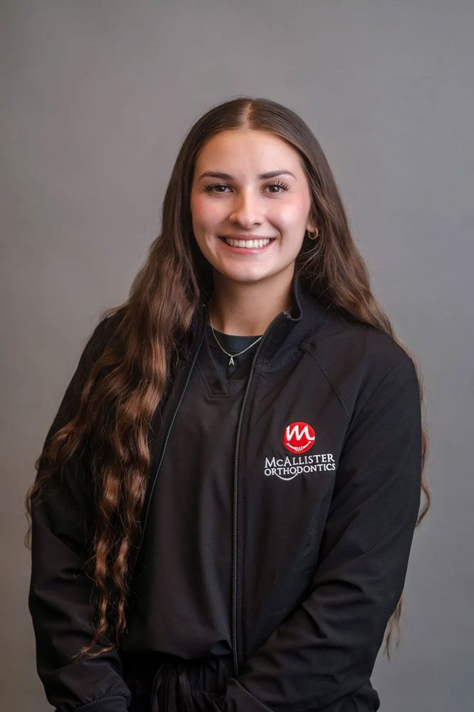 A woman is wearing a black jacket and smiling for the camera.