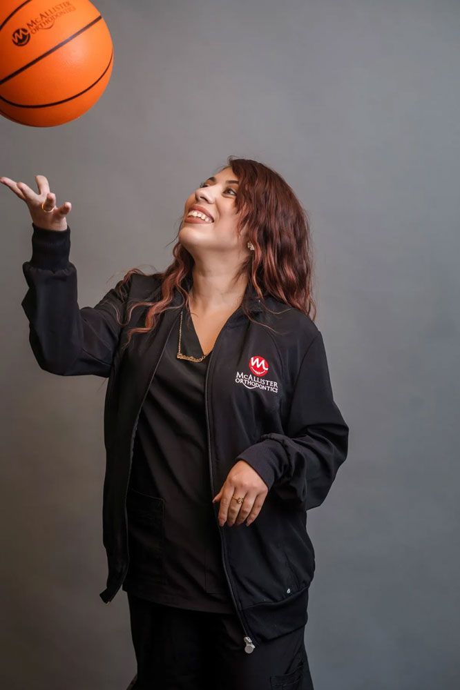 A man wearing a cowboy hat and sunglasses is holding a football.