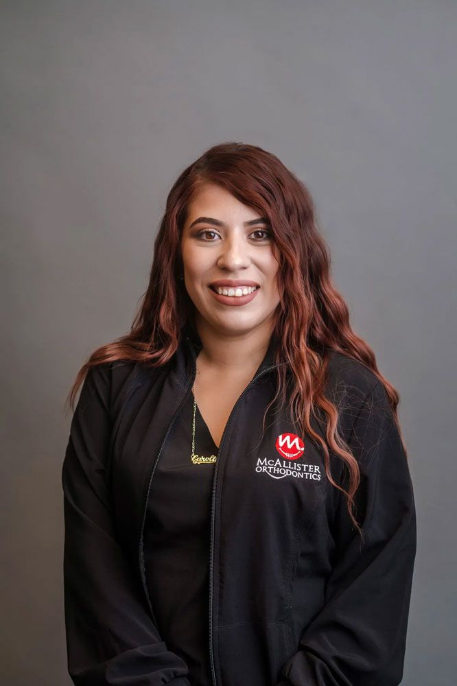 A young man wearing glasses and braces is smiling for the camera.