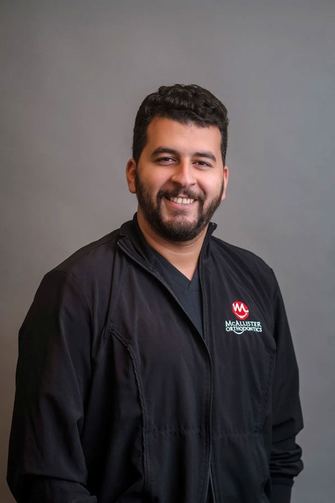 A woman is wearing a black jacket and smiling for the camera.
