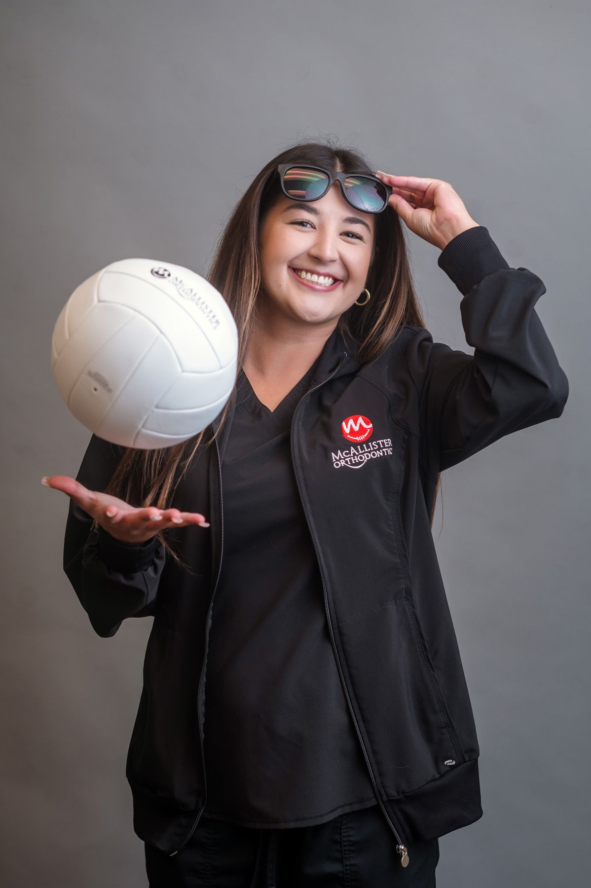 A woman is holding a beach ball and smiling.