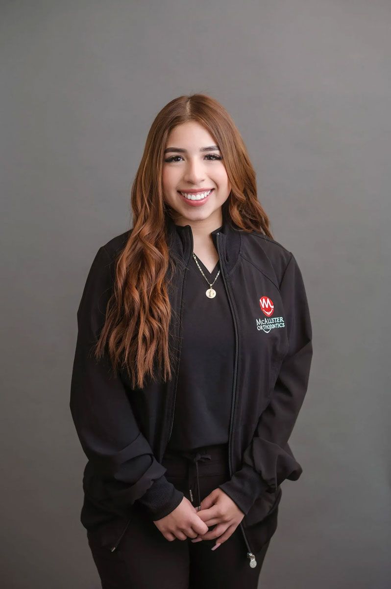 A woman is wearing a black jacket and smiling for the camera.