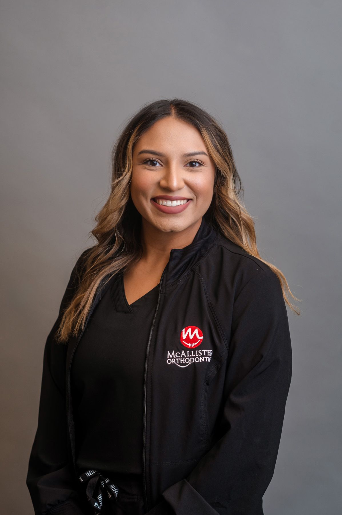 A young man wearing glasses and braces is smiling for the camera.