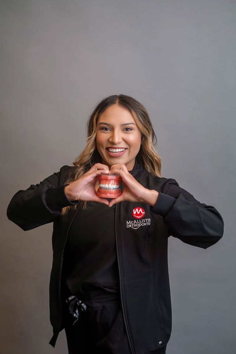 A man wearing a cowboy hat and sunglasses is holding a football.