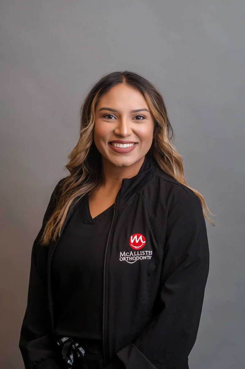 A young man wearing glasses and braces is smiling for the camera.