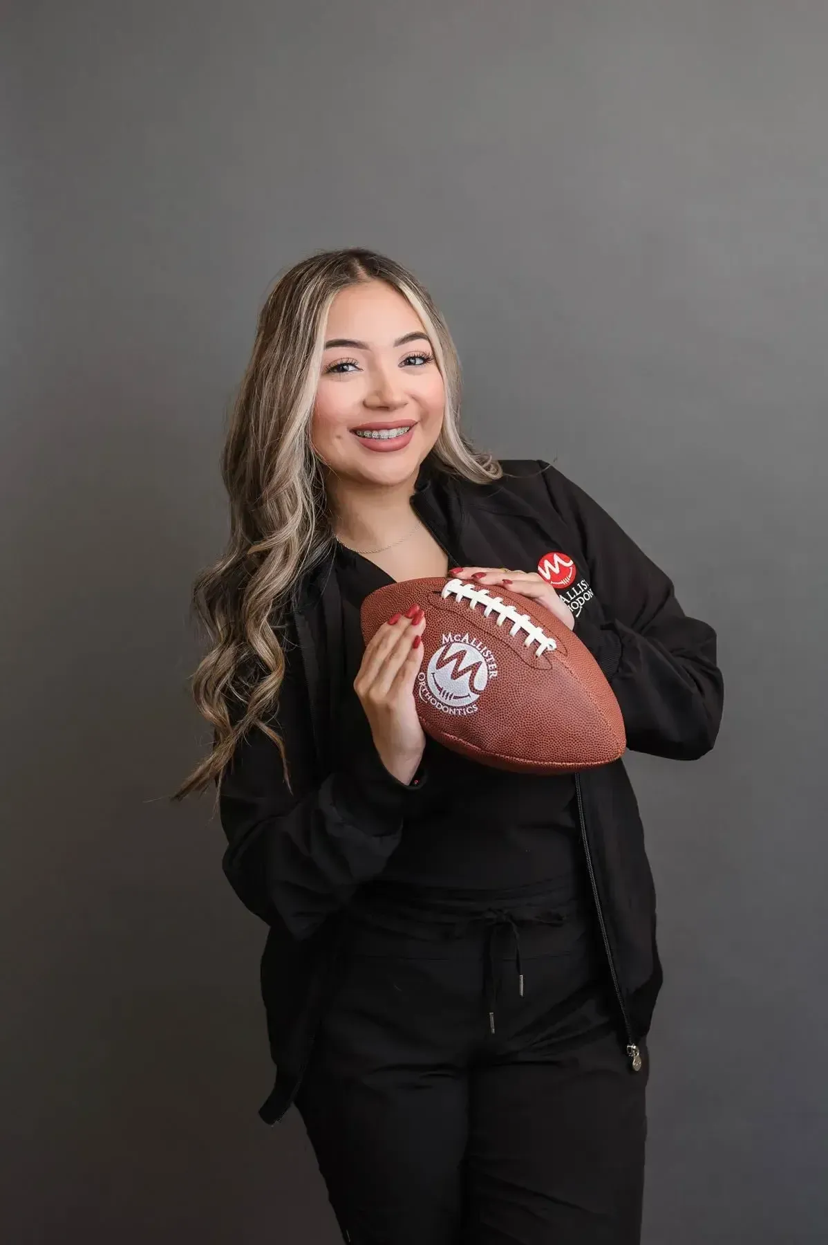A woman is holding a football in her hands.