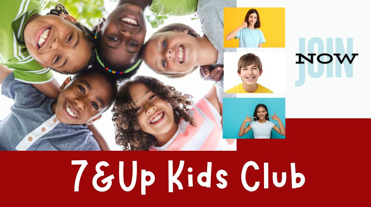 A boy wearing sunglasses is pointing at the camera.