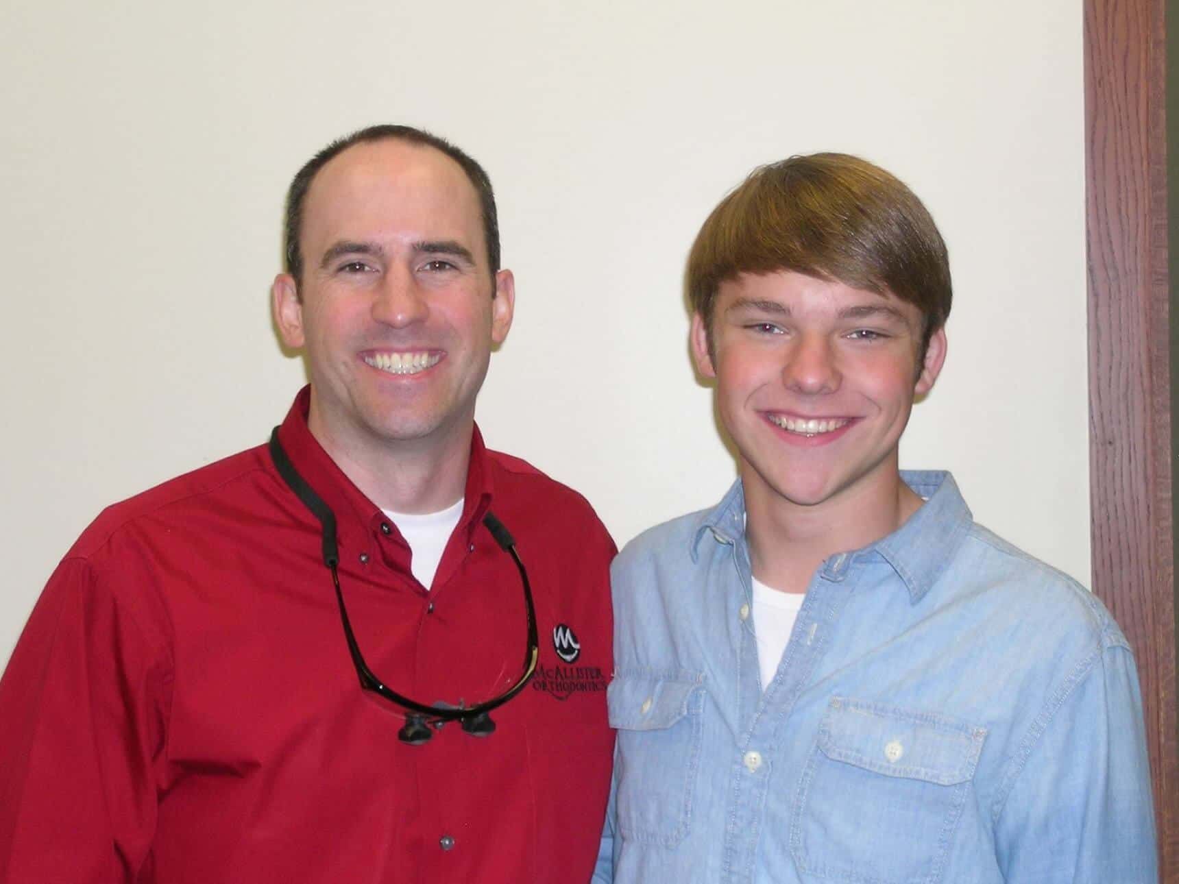 A man in a red shirt is standing next to another man in a blue shirt
