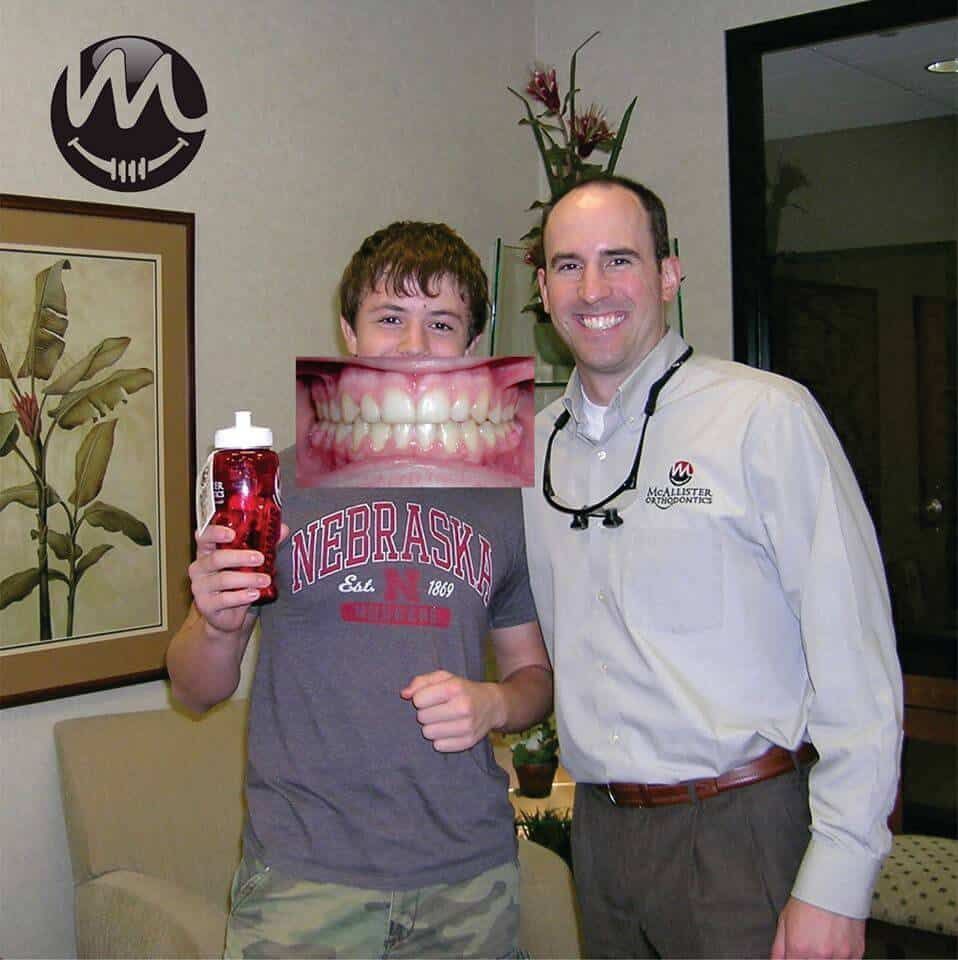 Two men standing next to each other with one wearing a Nebraska shirt