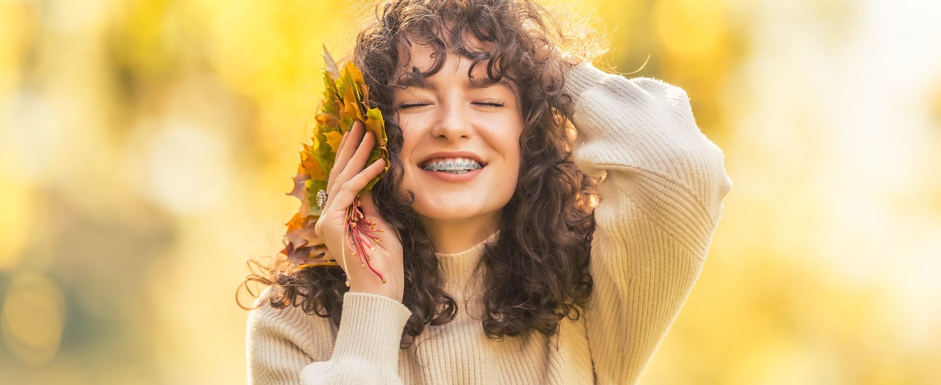 woman holding leaves up to her head