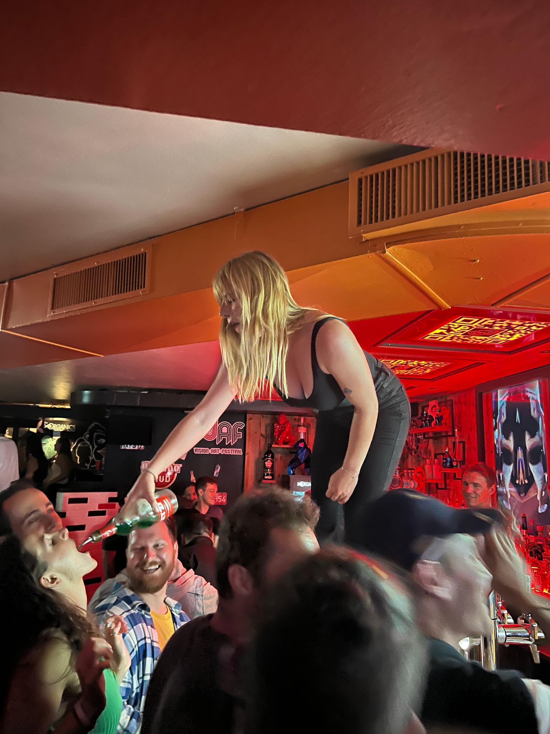 Une femme est debout sur une table devant une foule de personnes
