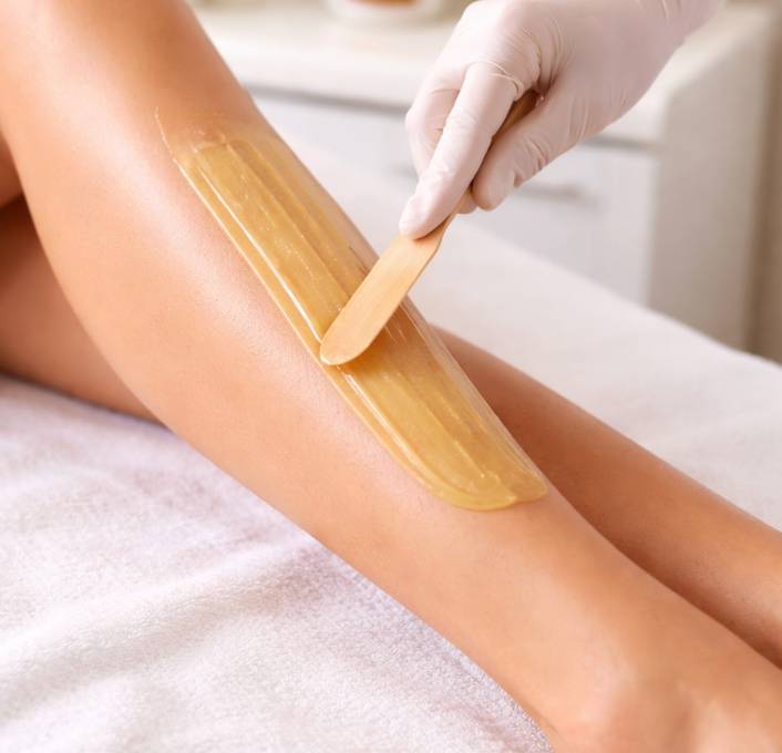 Hands Applying Wax Strip To A Person's Back During Hair Removal — Penelope's Beauty in Medowie, NSW