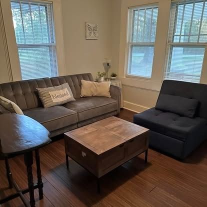 A living room with a couch , chair , table and coffee table.