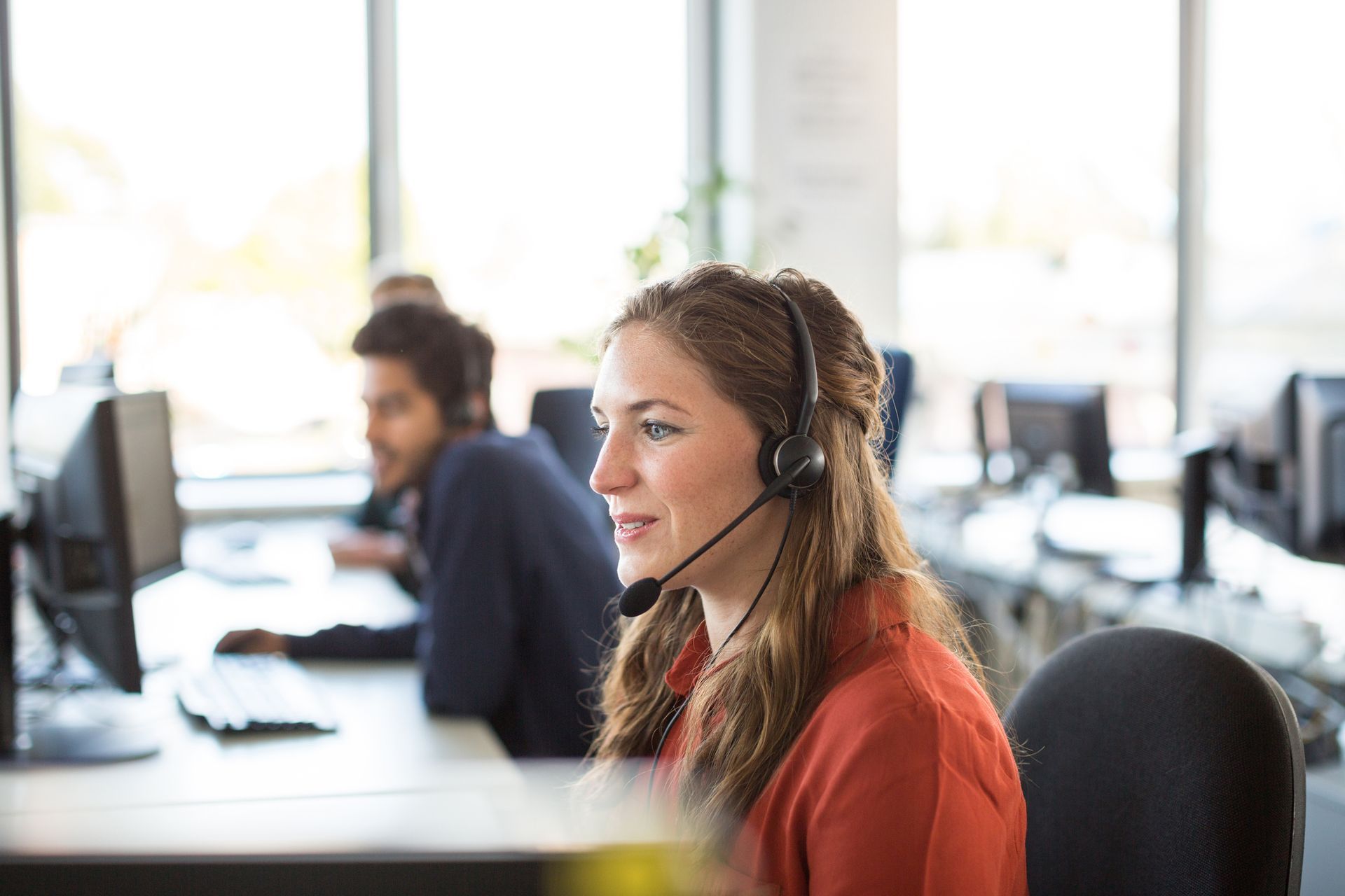 Female operator with a black headset at Kim's Answering Service, providing business phone answering 