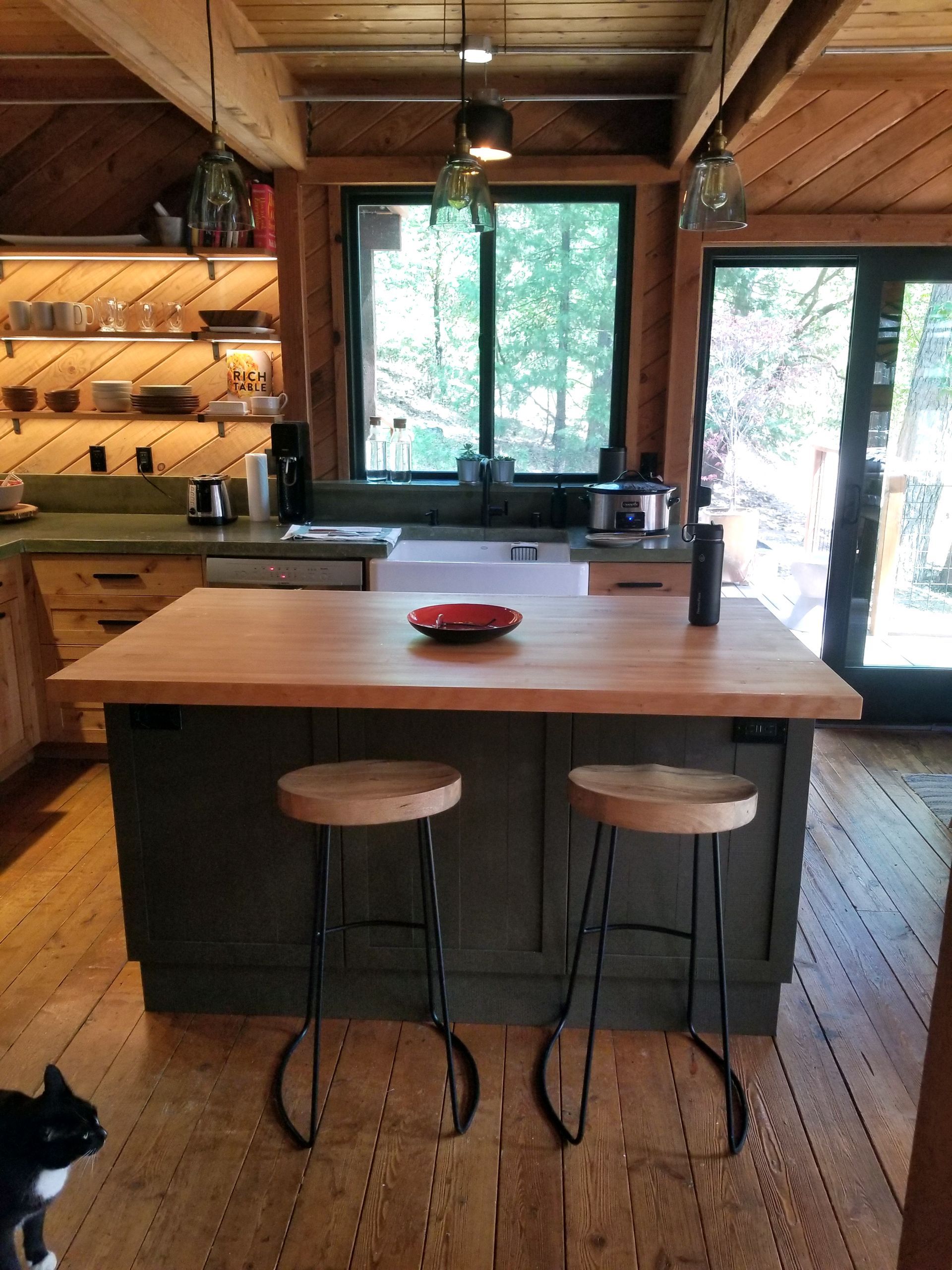 A kitchen with a large island and two stools