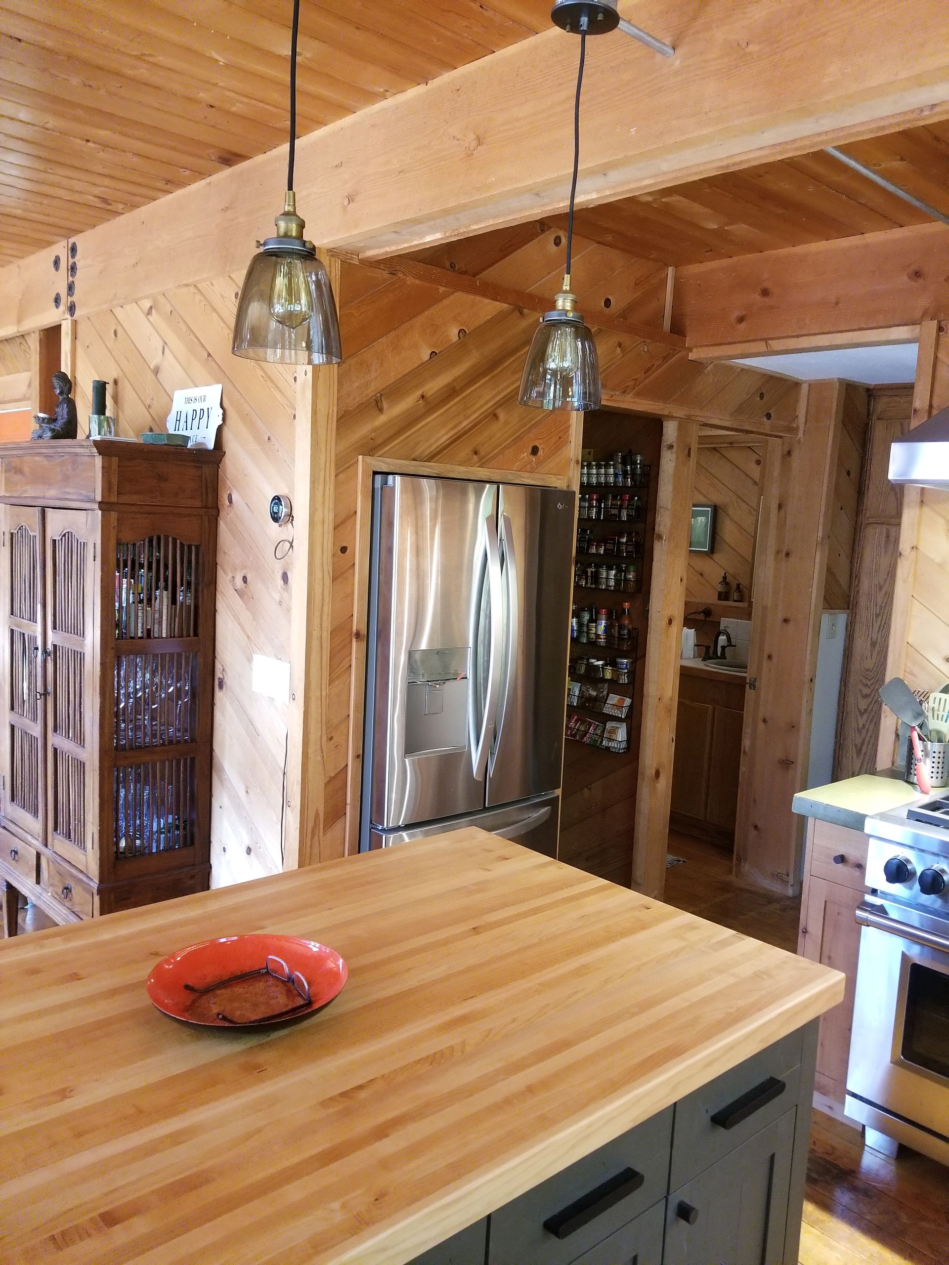 A kitchen with a stainless steel refrigerator and a wooden counter top