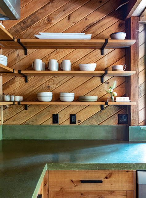 A kitchen with wooden shelves and a green counter top