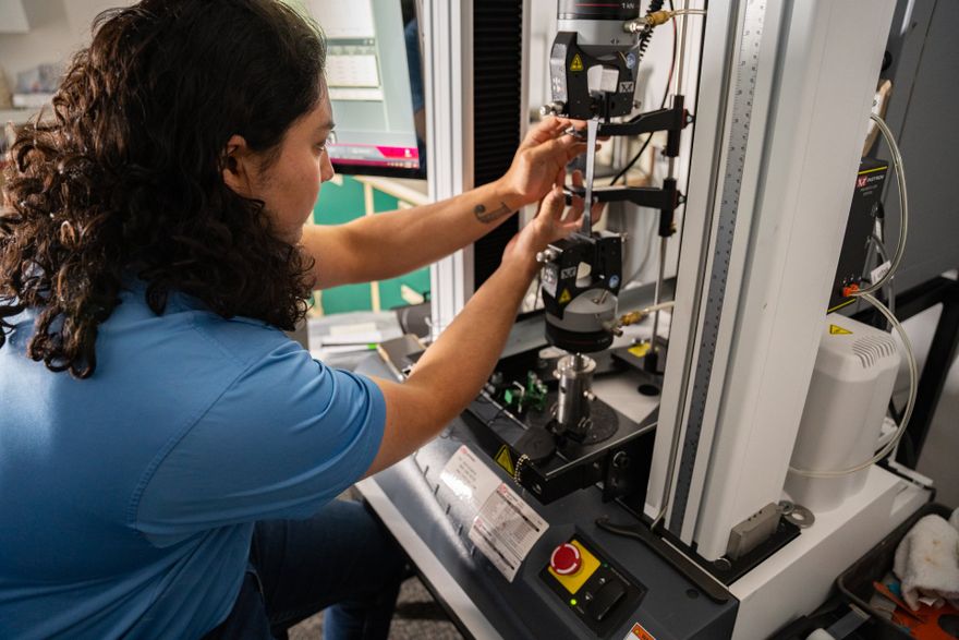 a woman is working on a machine in a lab