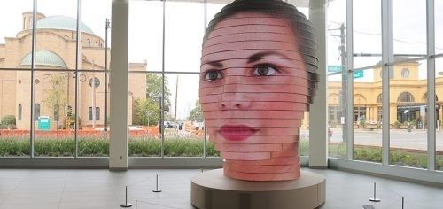 A statue of a woman 's face made out of cardboard.