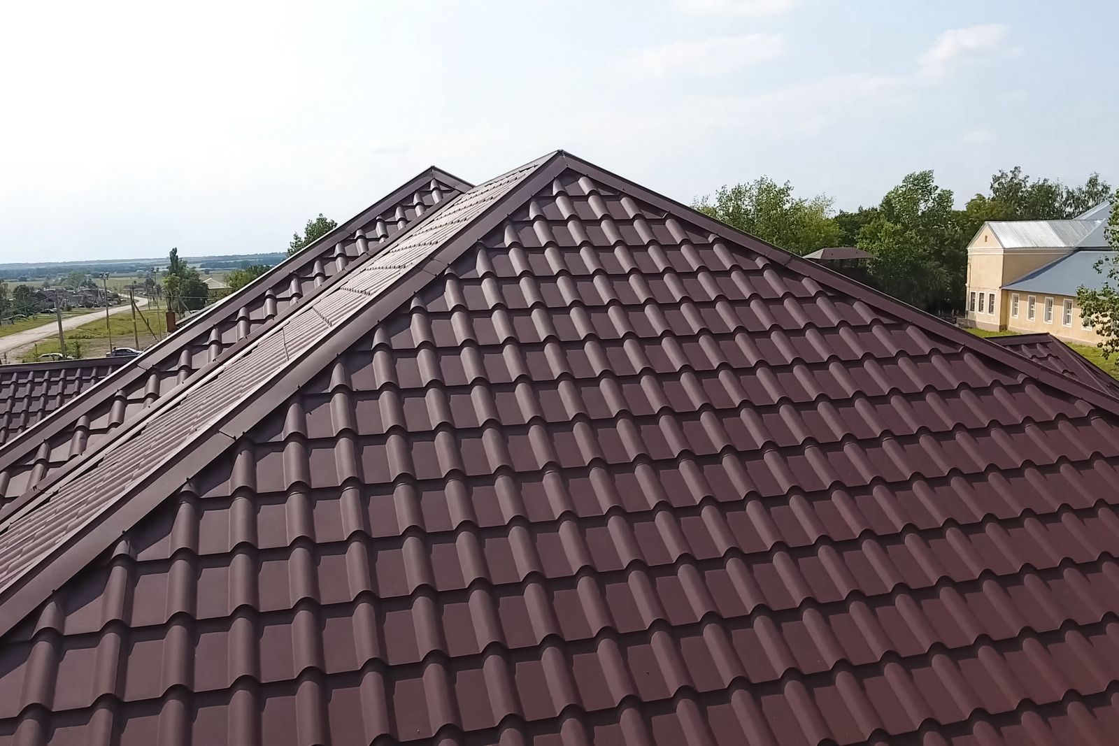 Man on deck with damaged roof, ladder, and building. Debris on the deck.