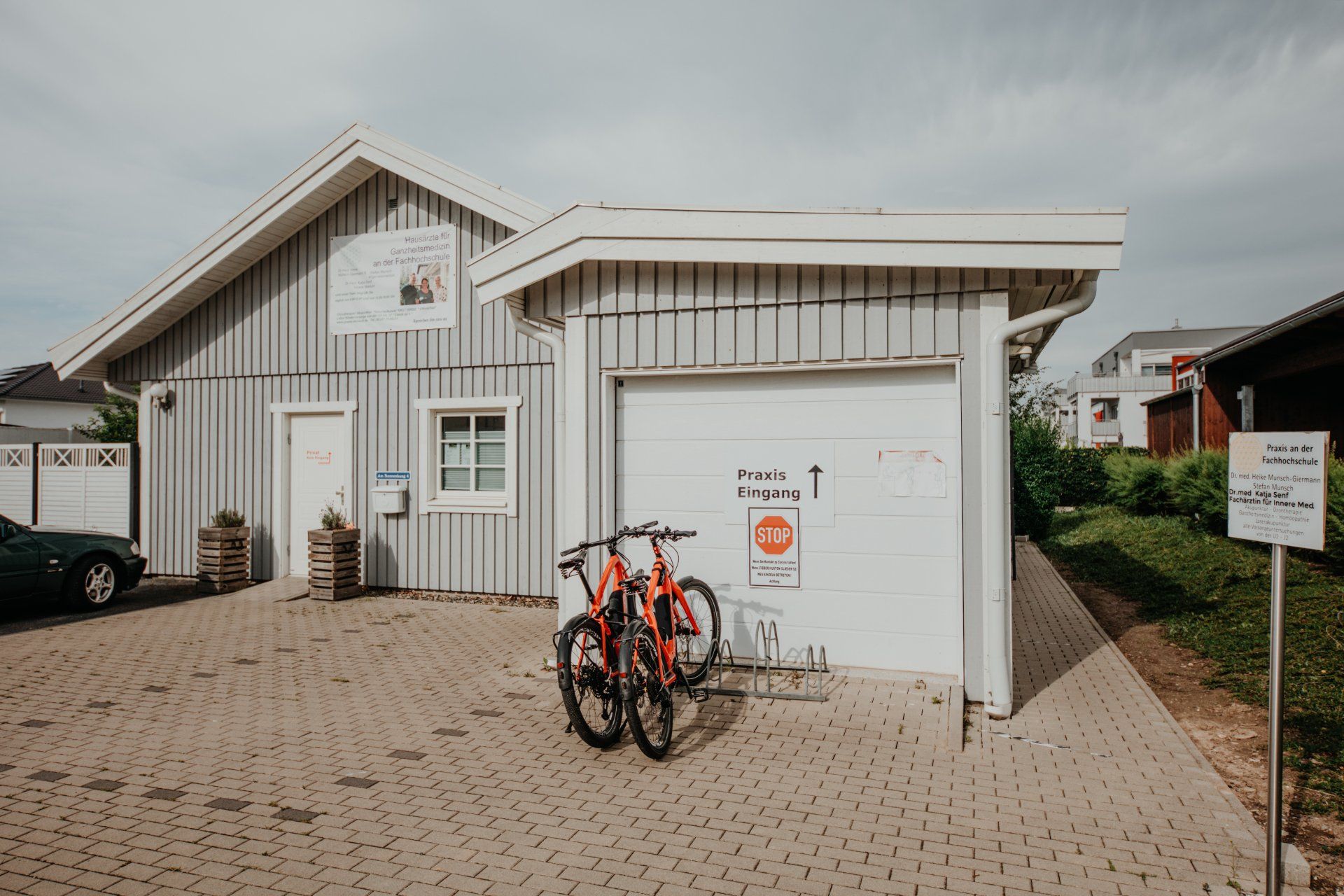 Vor einer Garage stehen zwei Fahrräder.