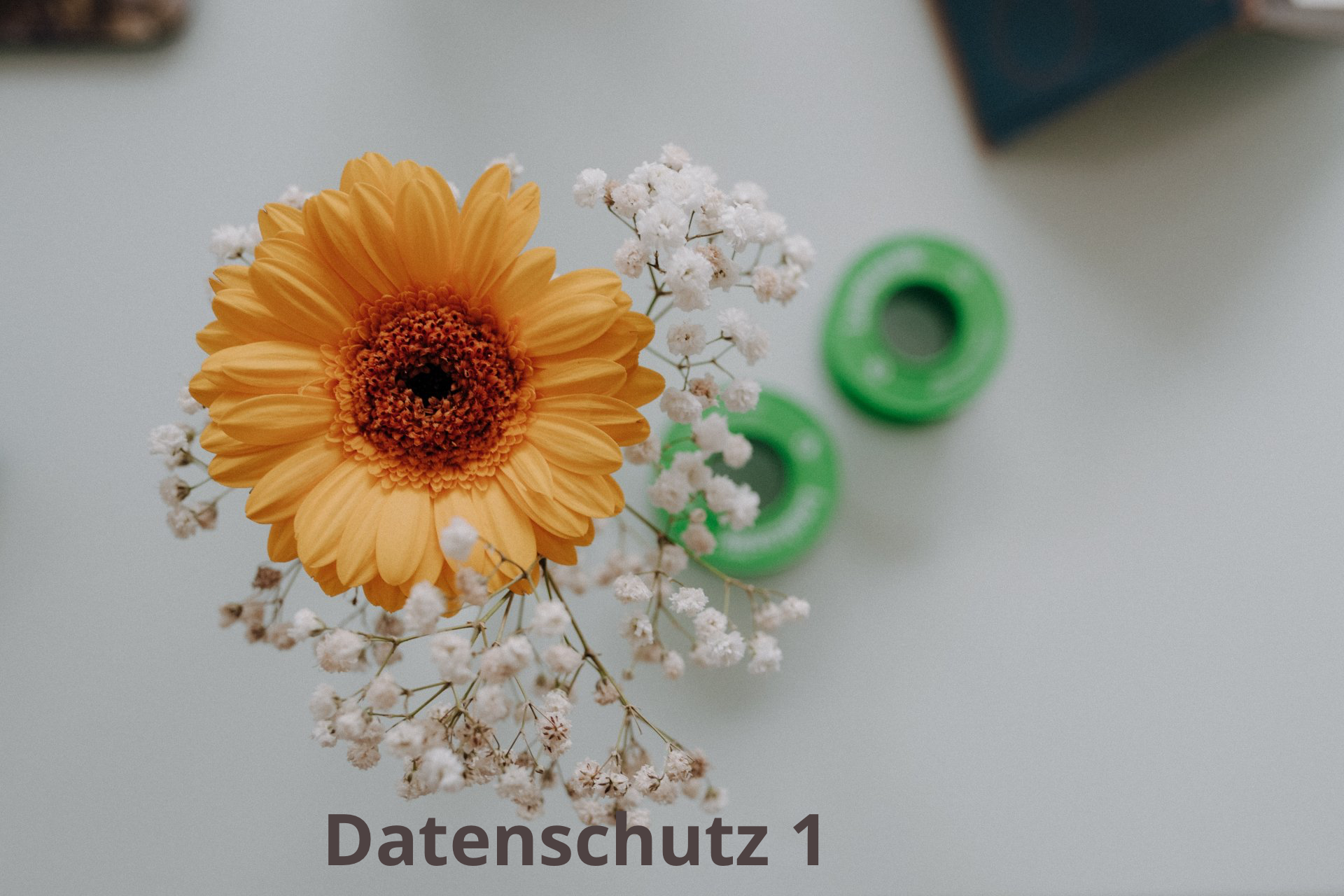 Eine Nahaufnahme einer gelben Blume mit Schleierkraut auf einem Tisch.