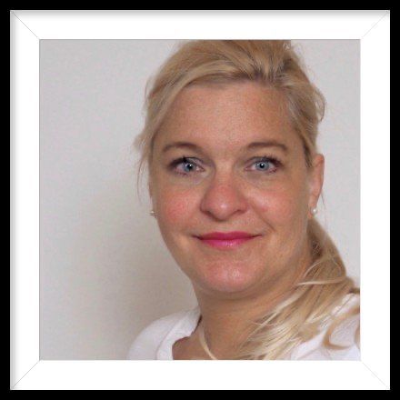 Eine Frau mit blonden Haaren und blauen Augen lächelt in die Kamera