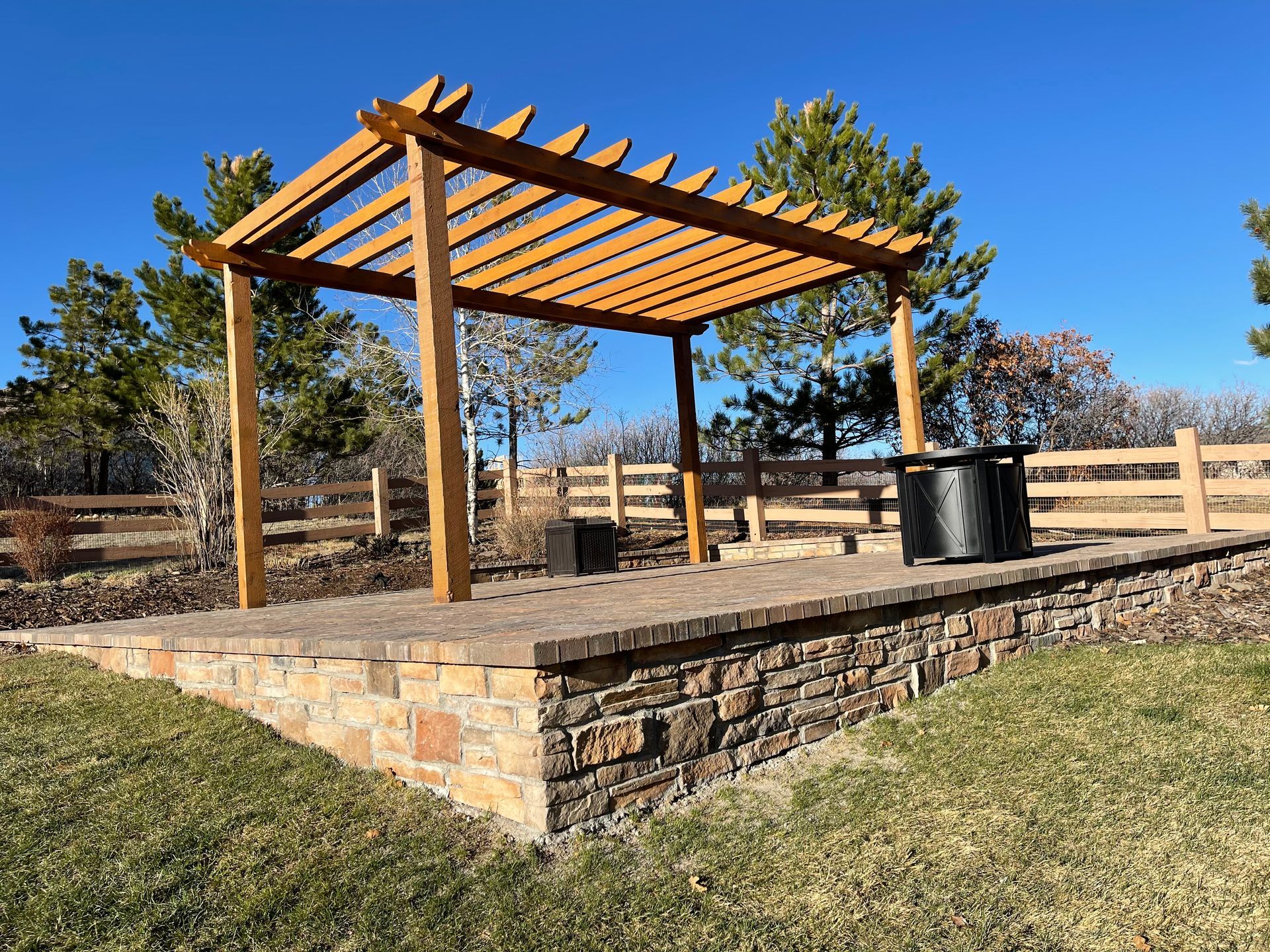 White gazebo with latticework sides, set in a garden with plants and brick path.