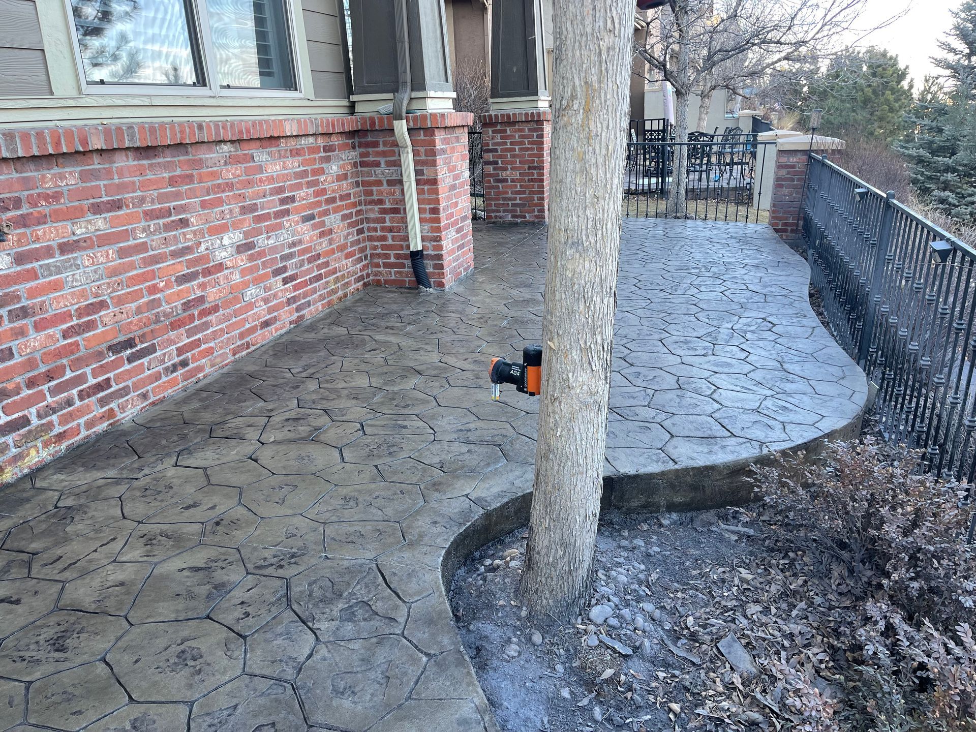 Circular brick patio in shades of red, orange, and brown, arranged in an arch pattern.