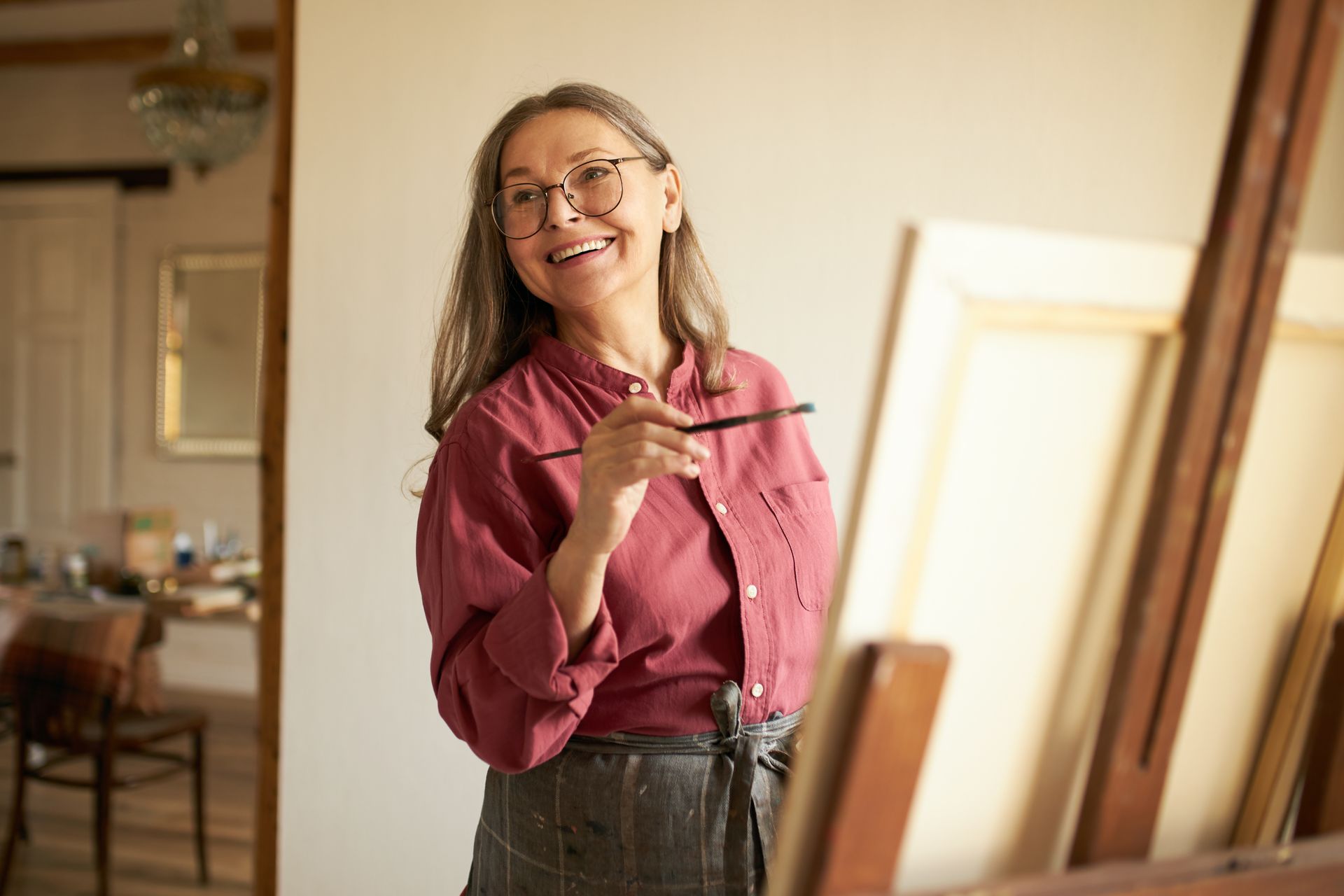 woman with paint brush smiling