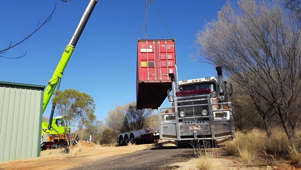 A Red Shipping Container Is Being Lifted Into A Truck By A Crane — Go Pack Yourself in Braitling, NT