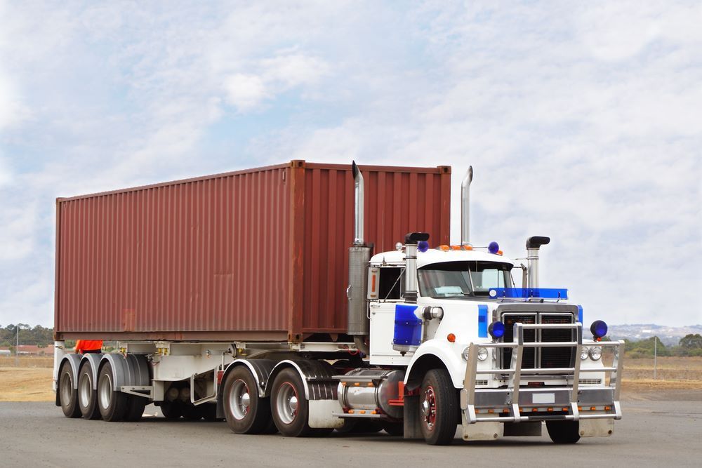 A White Semi Truck is Pulling a Red Shipping Container — Go Pack Yourself in Sydney, NSW