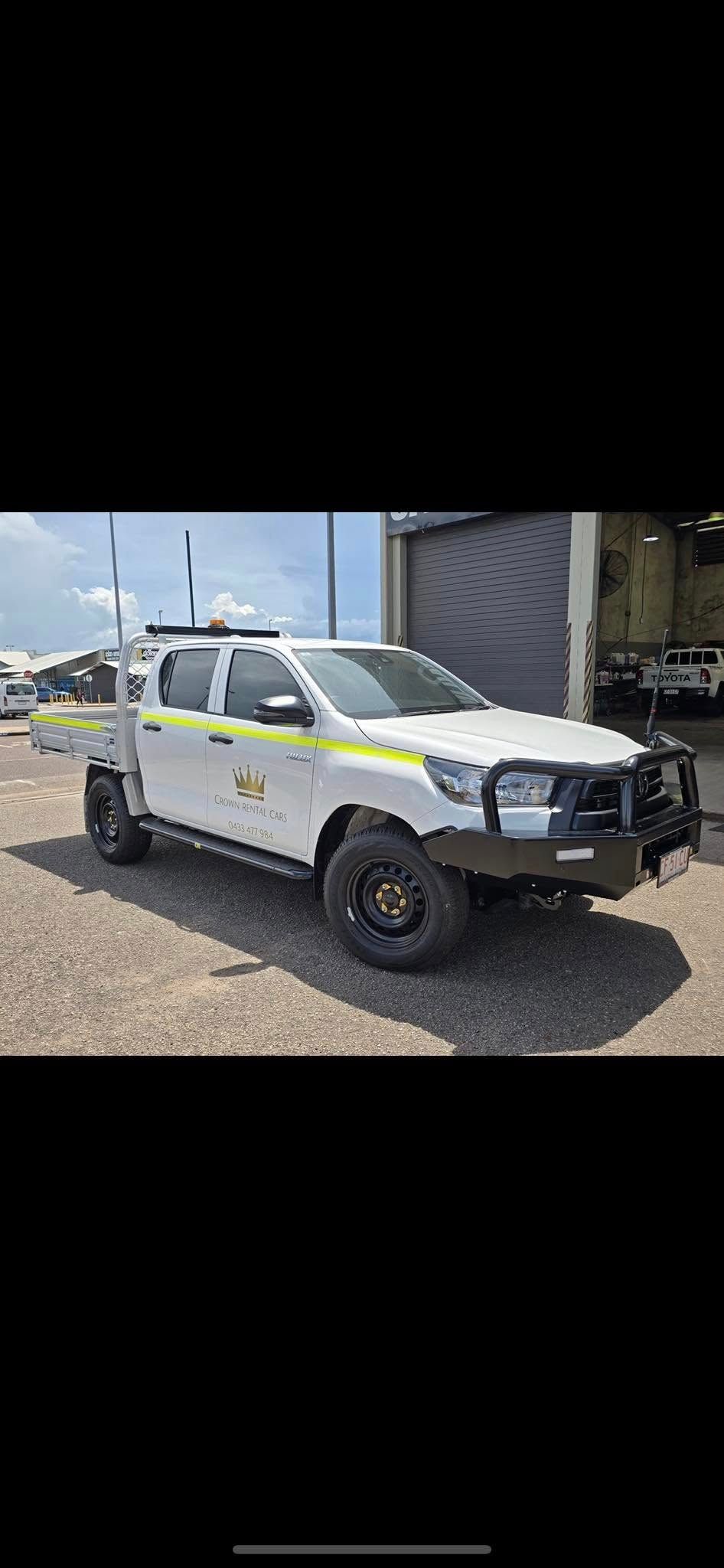 White Pickup Truck With Yellow Stripes Parked on Gravel — Crown Rental Cars in Nightcliff, NT