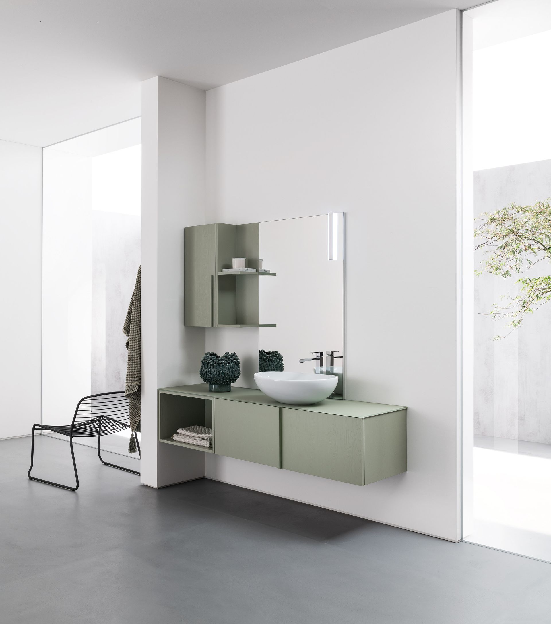 Mobiletto moderno per il bagno verde con specchio, mensola e lavandino bianco.