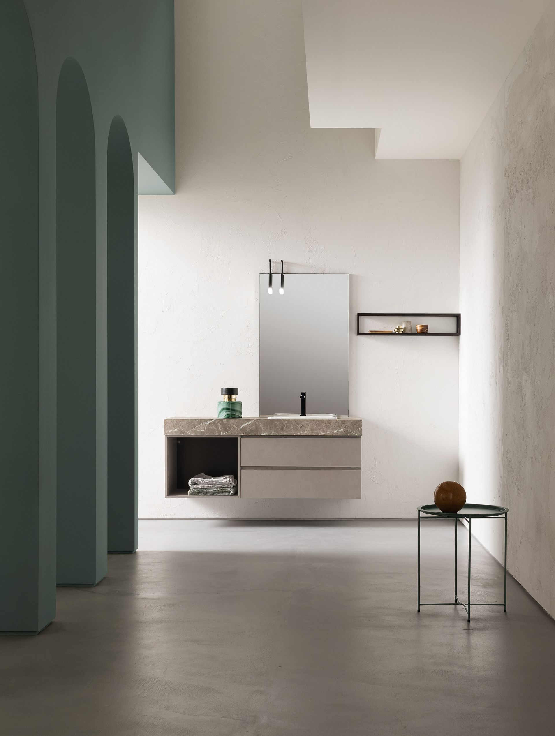 Bagno moderno con mobile lavabo sospeso, specchio e tavolino laterale. Tonalità grigio chiaro e verde.
