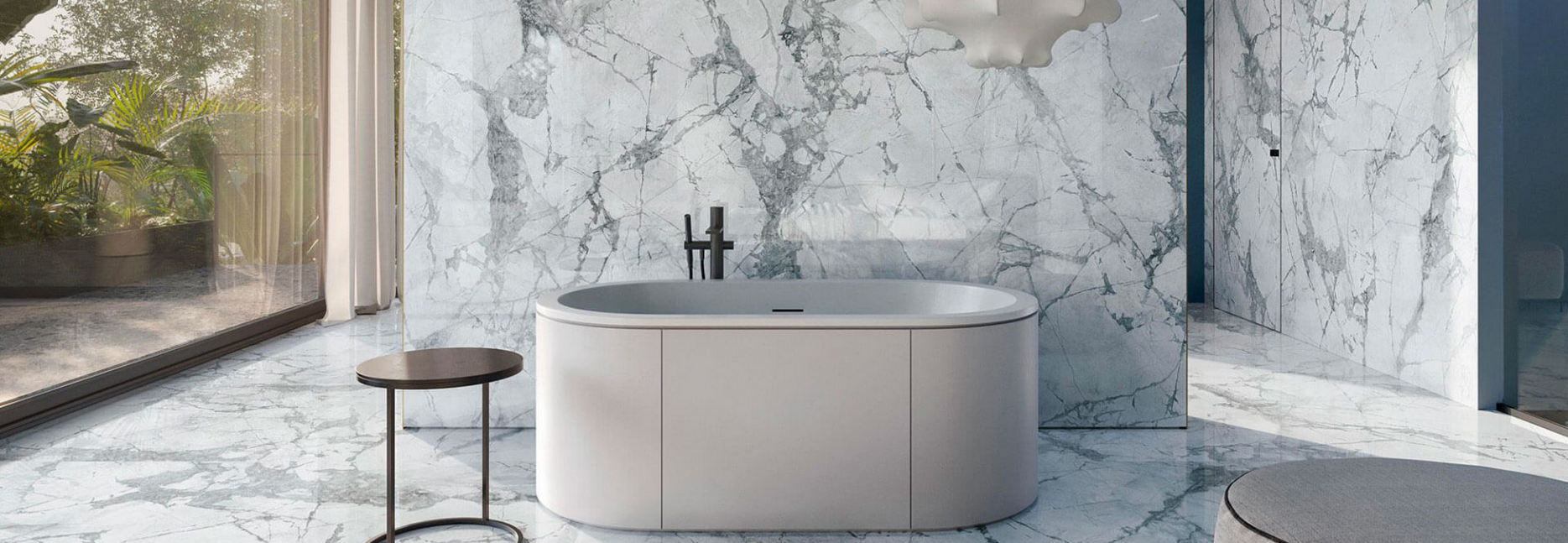 Bagno moderno con pareti in marmo bianco, vasca di colore chiaro e un piccolo tavolino laterale.