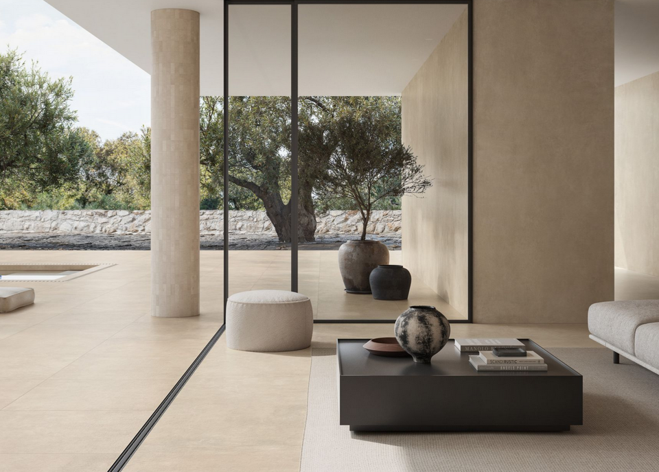 Soggiorno moderno con colori neutri, ampia finestra con vista su un albero e spazio esterno.