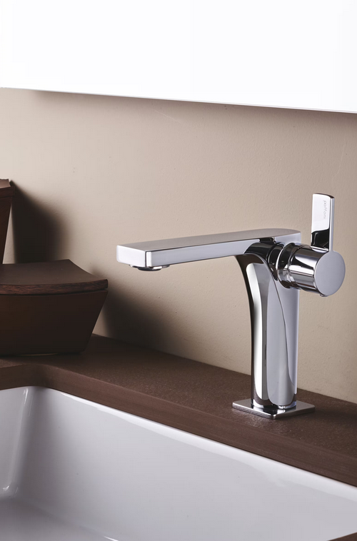 Rubinetto cromato su un piano di lavoro in legno scuro sopra un lavandino bianco.