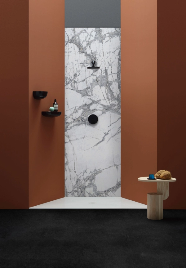 Box doccia moderno con schienale in marmo, pareti in bronzo e accessori neri.