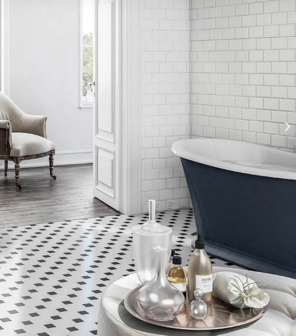 Bagno con pavimento a motivi bianchi e neri, parete con piastrelle bianche della metropolitana e vasca da bagno blu con piedini.